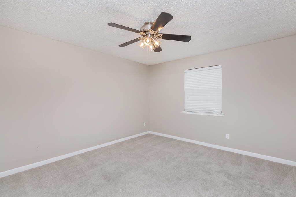 a bedroom with a ceiling fan and a window
