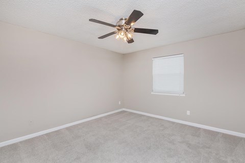a bedroom with a ceiling fan and a window