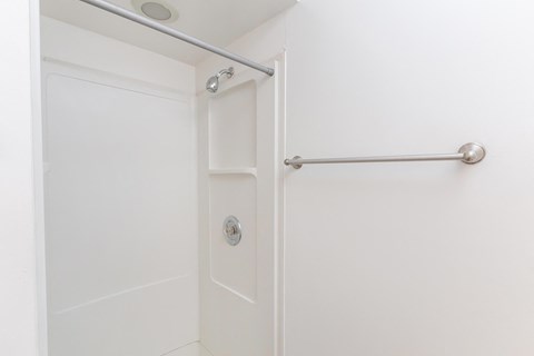 a white bathroom with a white shower and a white door