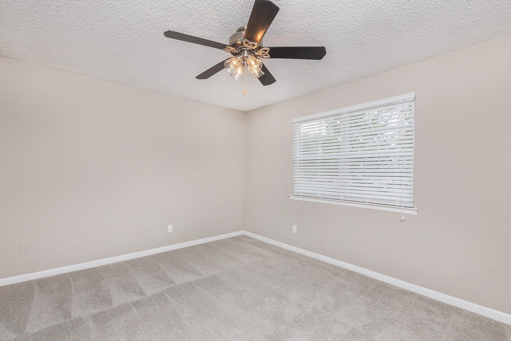 a bedroom with a ceiling fan and a window