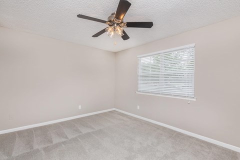a bedroom with a ceiling fan and a window