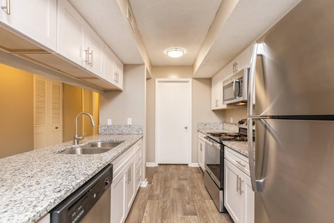 a kitchen with granite counter tops and stainless steel appliances