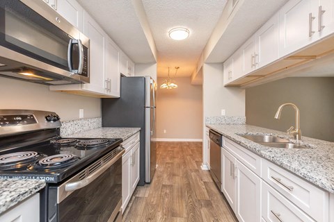a kitchen with white cabinets and stainless steel appliances