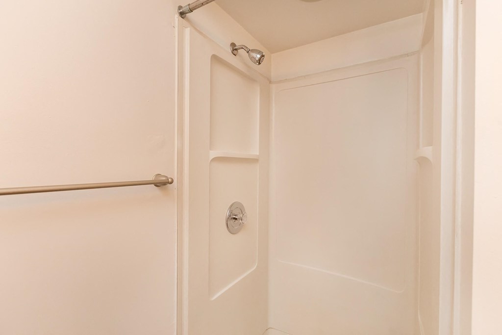 a white bathroom with a white door and a shower curtain