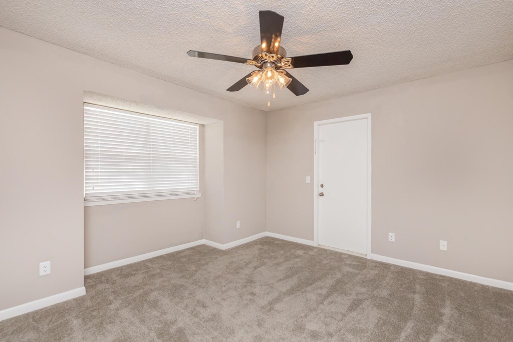 a bedroom with a ceiling fan and a window