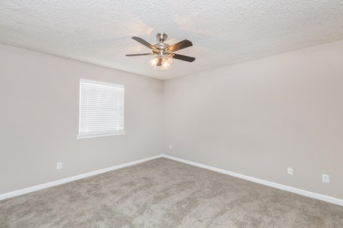 a bedroom with carpet and a ceiling fan