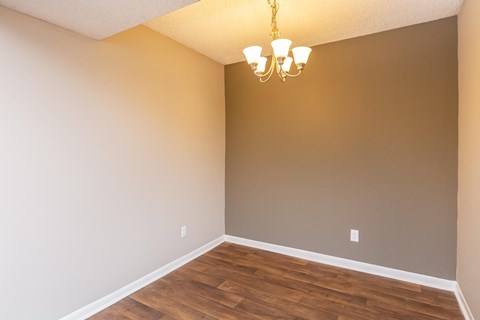 a empty living room with wood floors and a chandelier