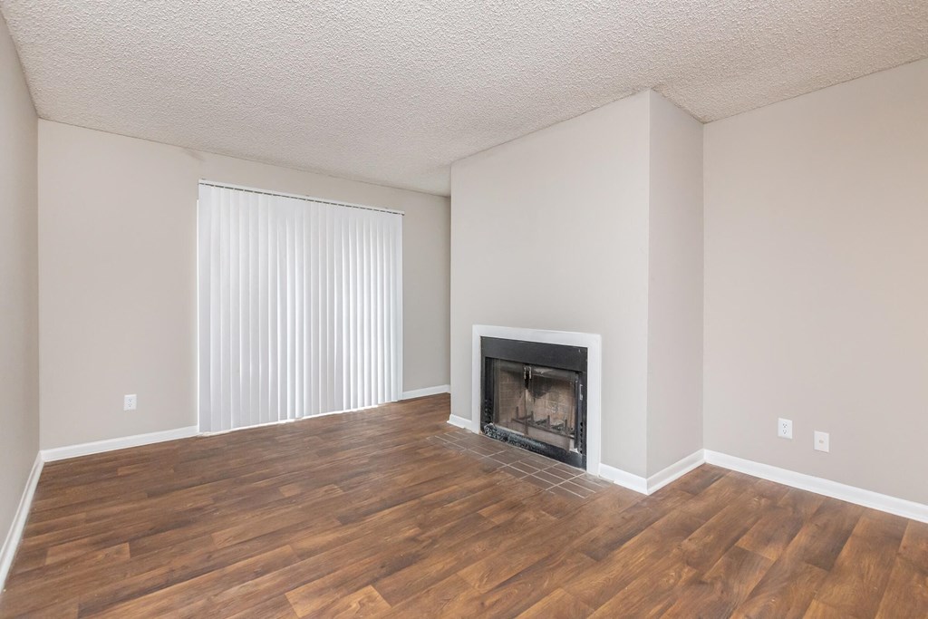 a living room with a fireplace and wooden floors