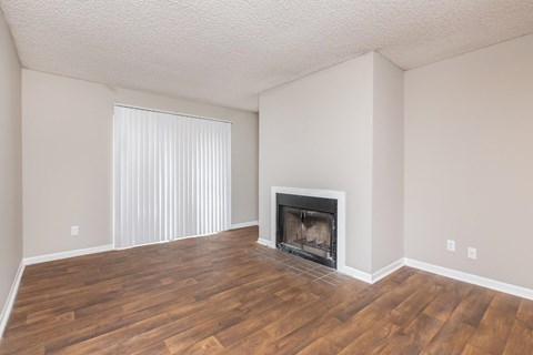 a living room with a fireplace and wooden floors