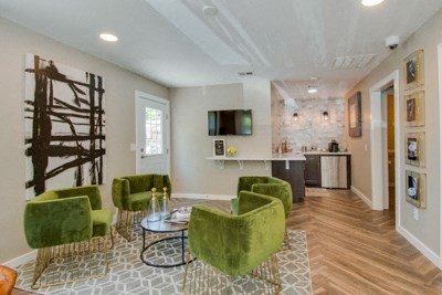 a living room with green chairs and a table
