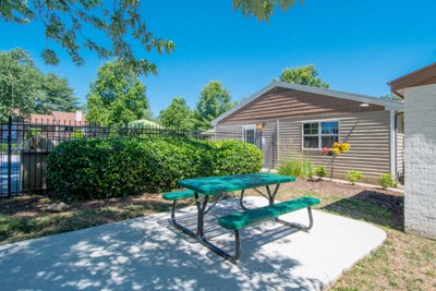 a picnic table in a yard in front of a house