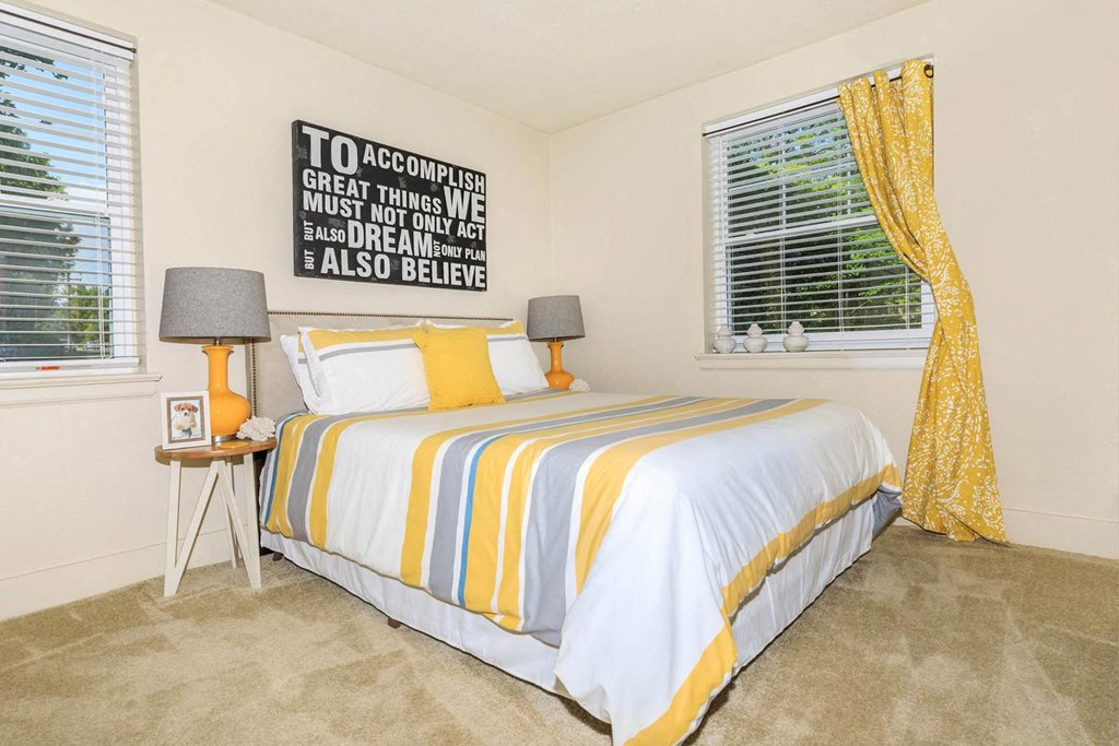 a bedroom with a bed and two windows