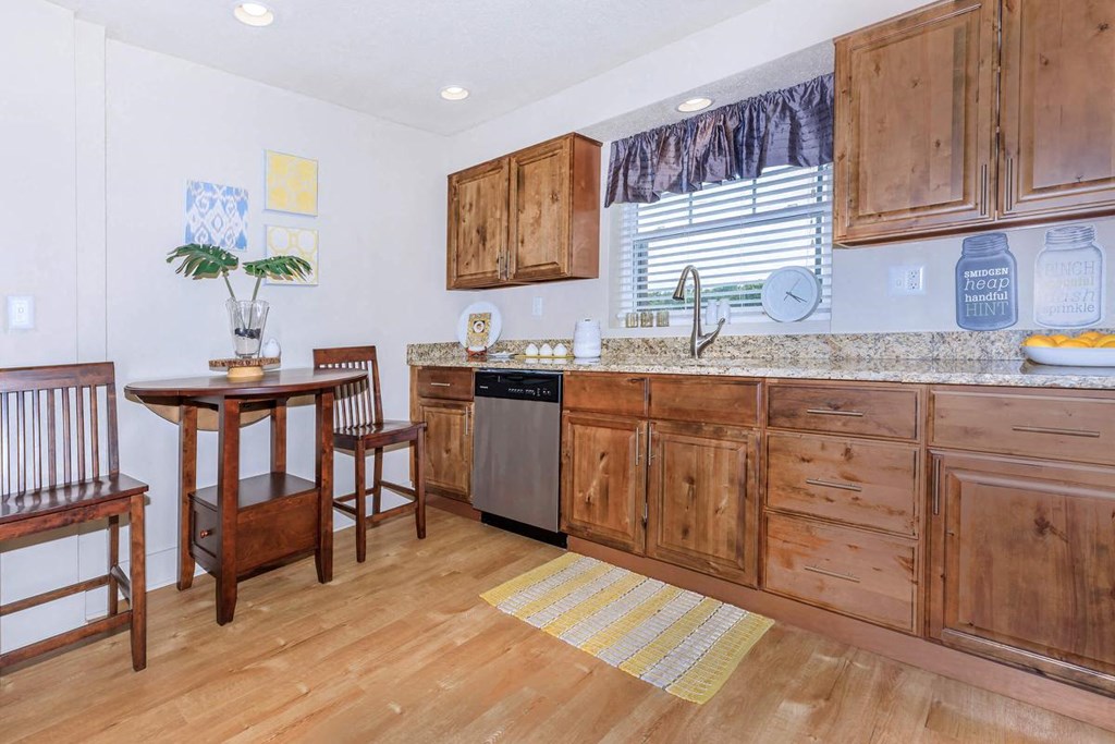 a kitchen with wooden cabinets and a table with chairs