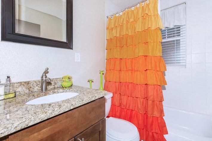 a bathroom with a shower curtain and a sink and a toilet