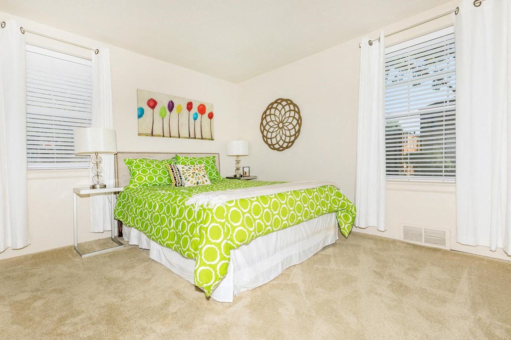 a bedroom with a bed and two windows