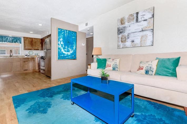 a living room with a blue table and a white couch