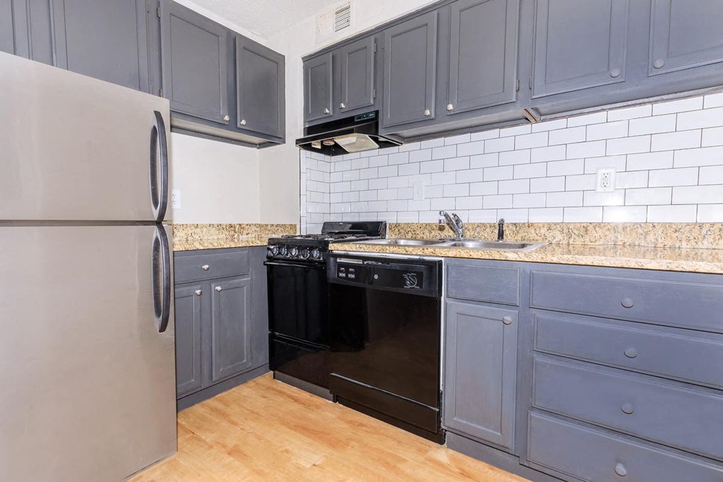 a kitchen with gray cabinets and a black stove and refrigerator