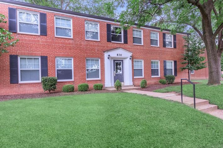 a brick building with a lawn in front of it