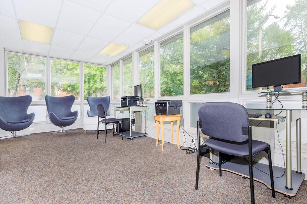 a room with chairs and a desk and a television