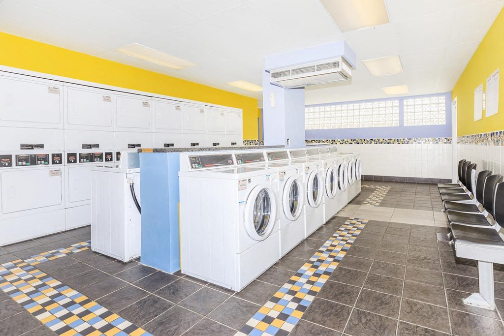 a row of washers and dryers in a laundry room