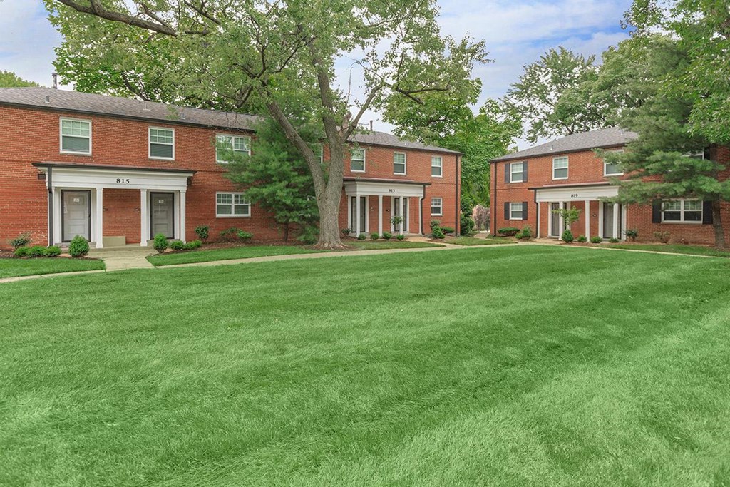 a green lawn in front of a brick building
