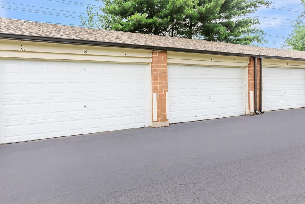 a white garage door in front of a brick building
