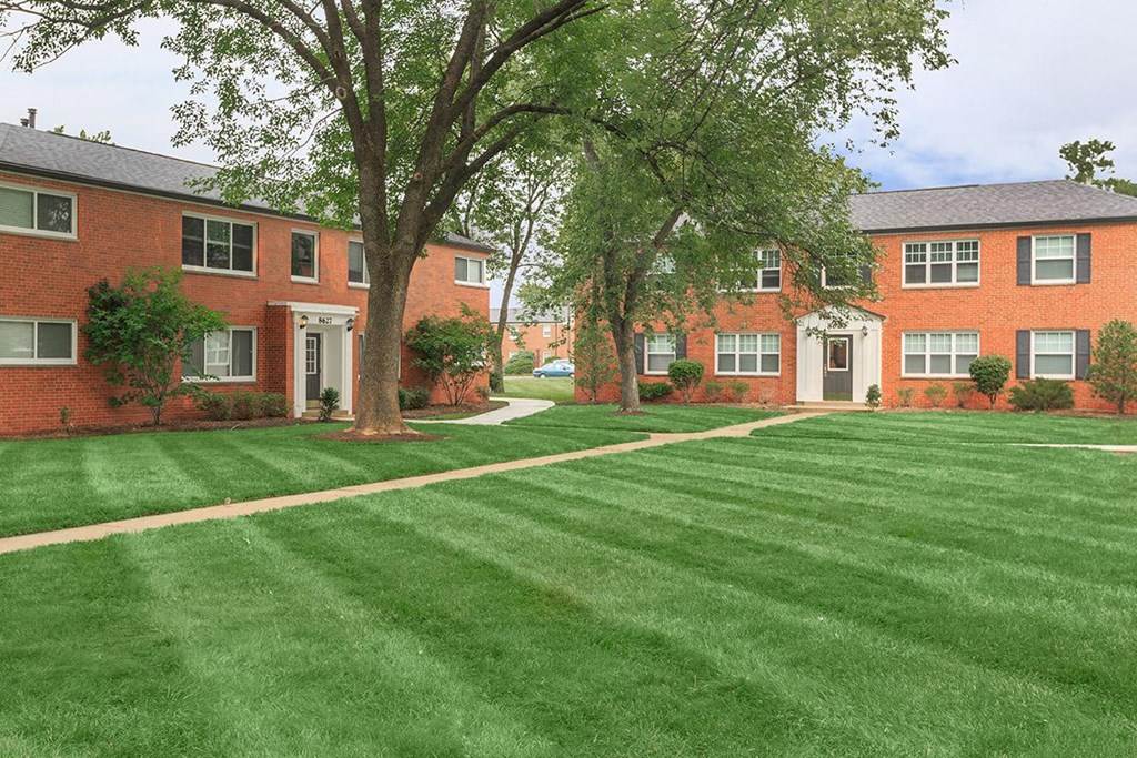 a lush green lawn in front of an apartment building