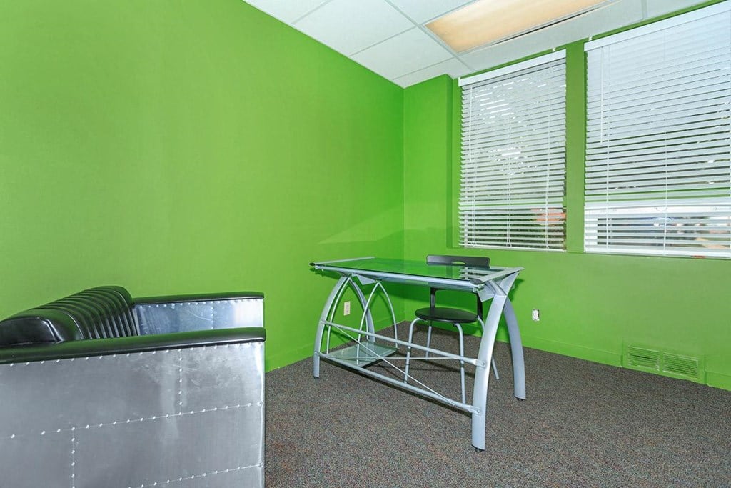 a green room with a desk and a chair