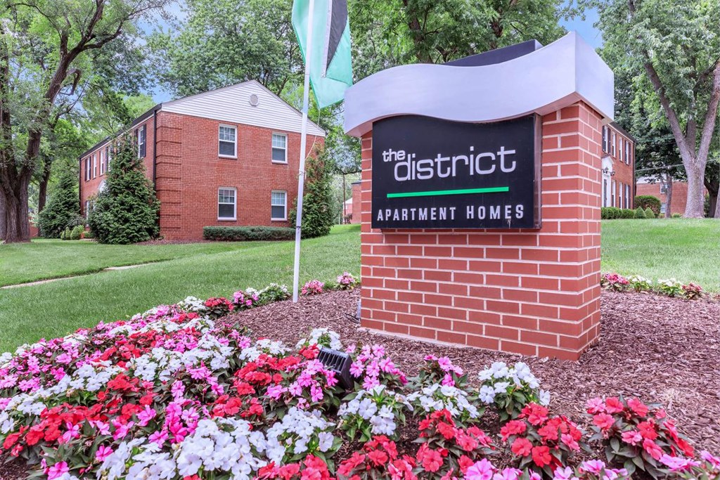 our apartments offer a beautiful yard with flowers and a sign