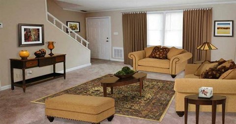 a living room with couches and chairs and a rug