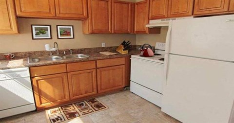 a kitchen with white appliances and wooden cabinets