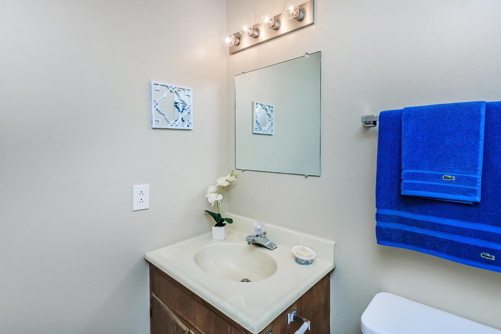 a bathroom with a sink and a mirror and blue towels