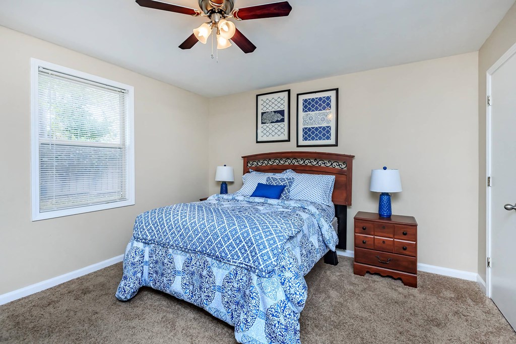 a bedroom with a bed and a ceiling fan
