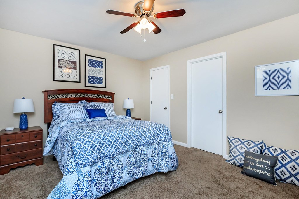 a bedroom with a bed and a ceiling fan