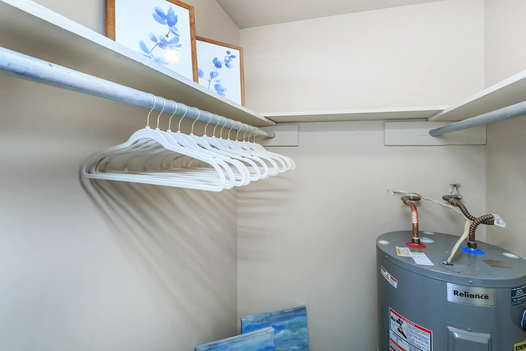 a closet with a bundle of clothes and a water hose