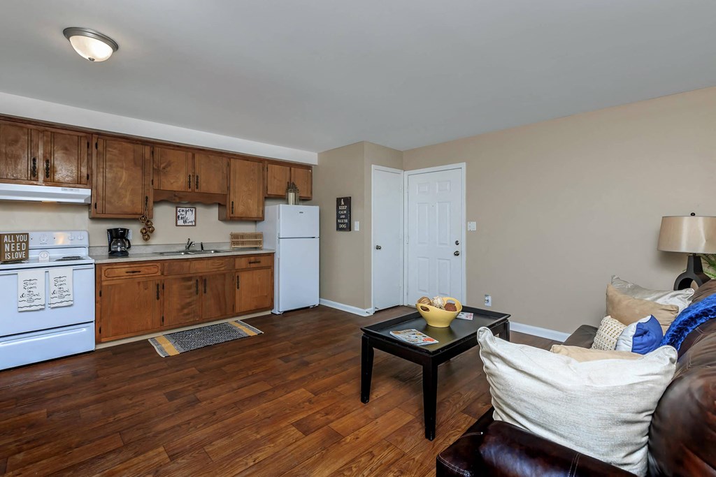 a kitchen and living room with wooden floors and white appliances