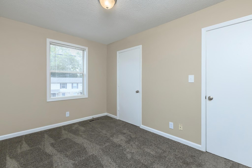 a room with carpet and a door and a window