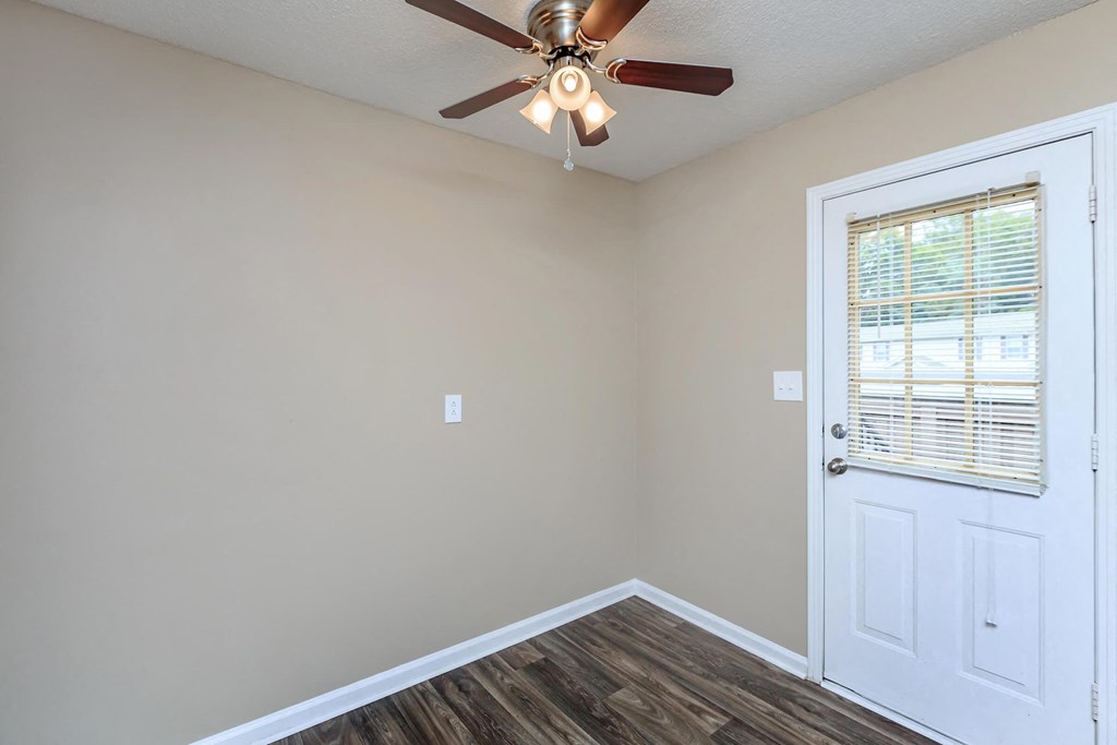 the interior of a room with a ceiling fan and a door