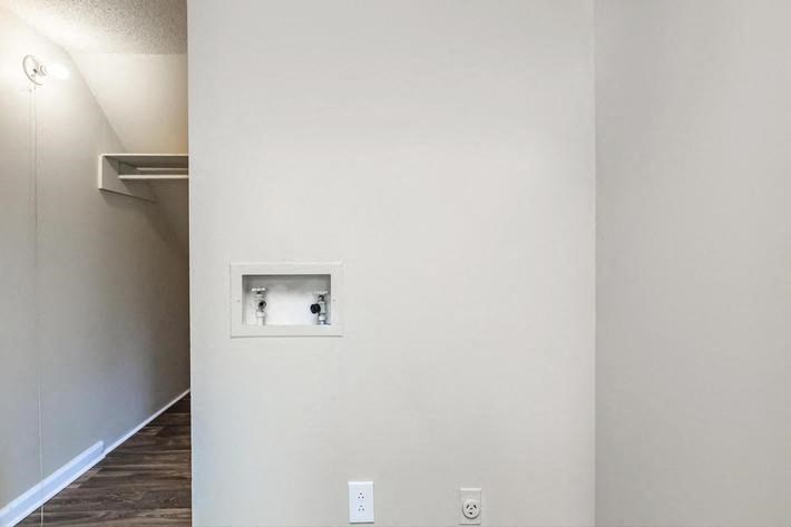 a white wall with an outlet on the side of it
