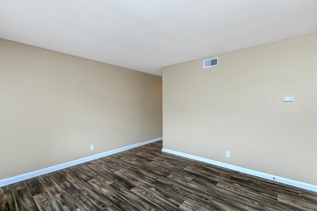 a living room with wood flooring and beige walls