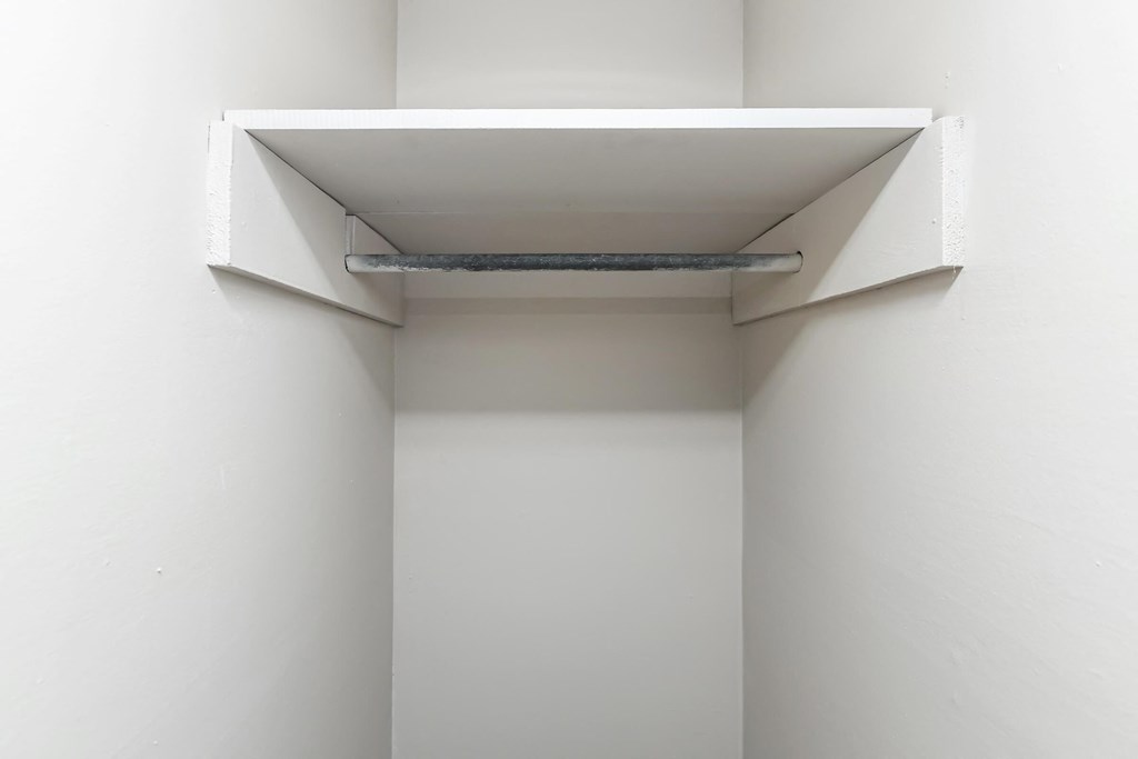 a white room with a white ceiling and a white shelf on the wall