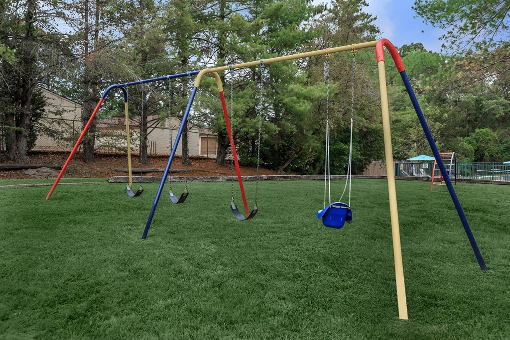 a swing set with four swings on it in a park