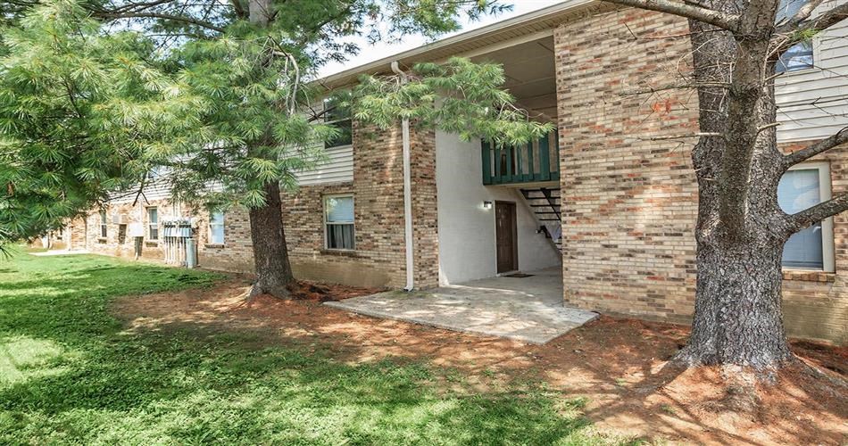 the front of a brick building with trees