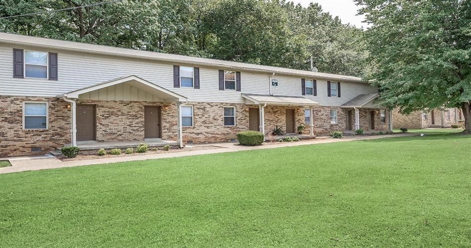 a white house with a green lawn in front of it