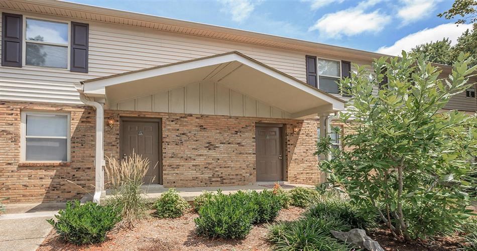 a house with a front porch and a brick wall
