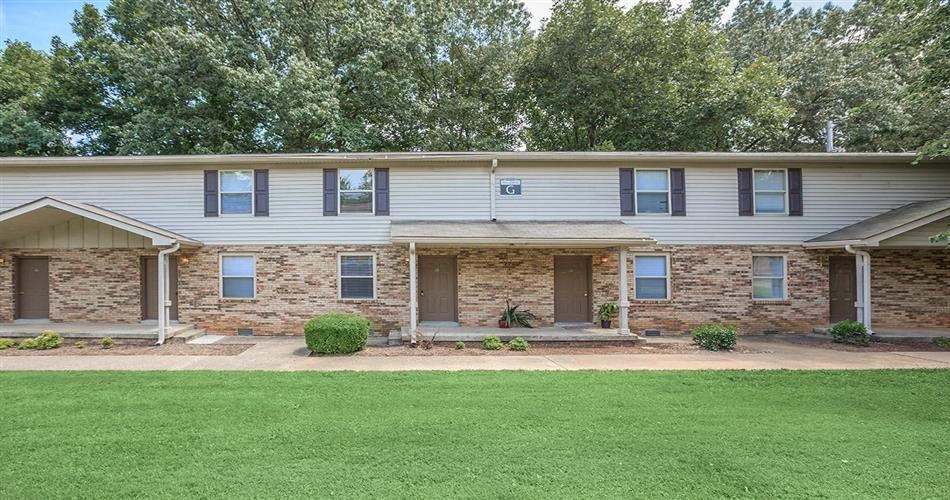 a brick and with a lawn and a porch