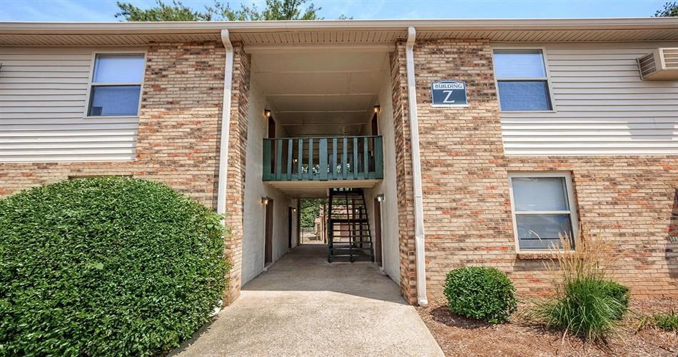a brick building with a balcony and a walkway