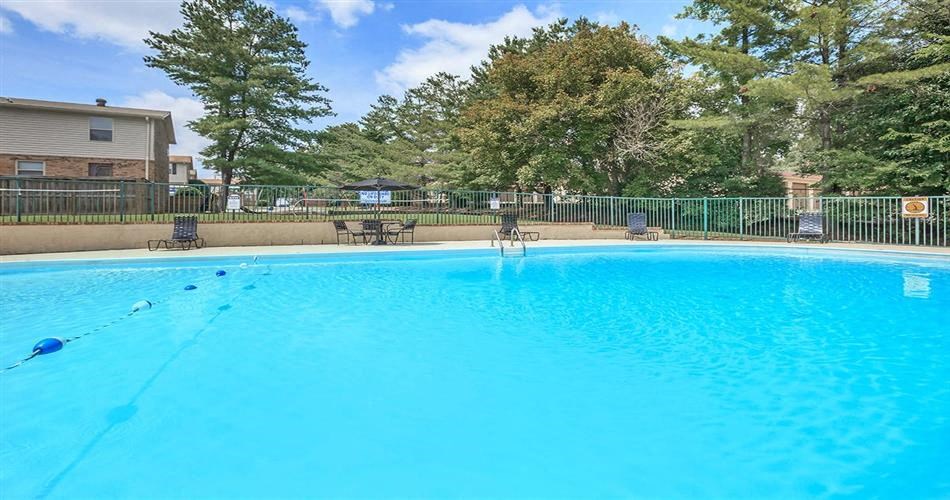 a large blue pool with a fence around it