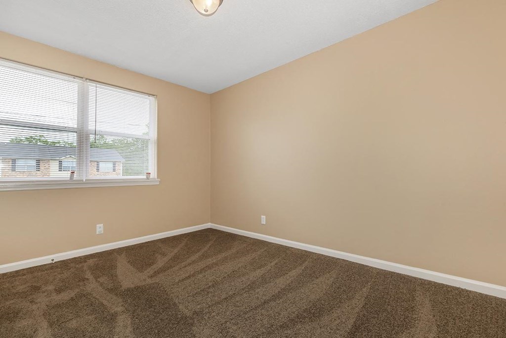 an empty room with carpet and a window