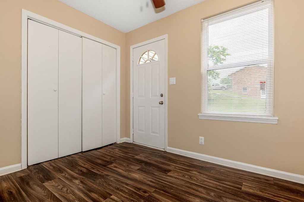 a bedroom with a door and a window and a closet
